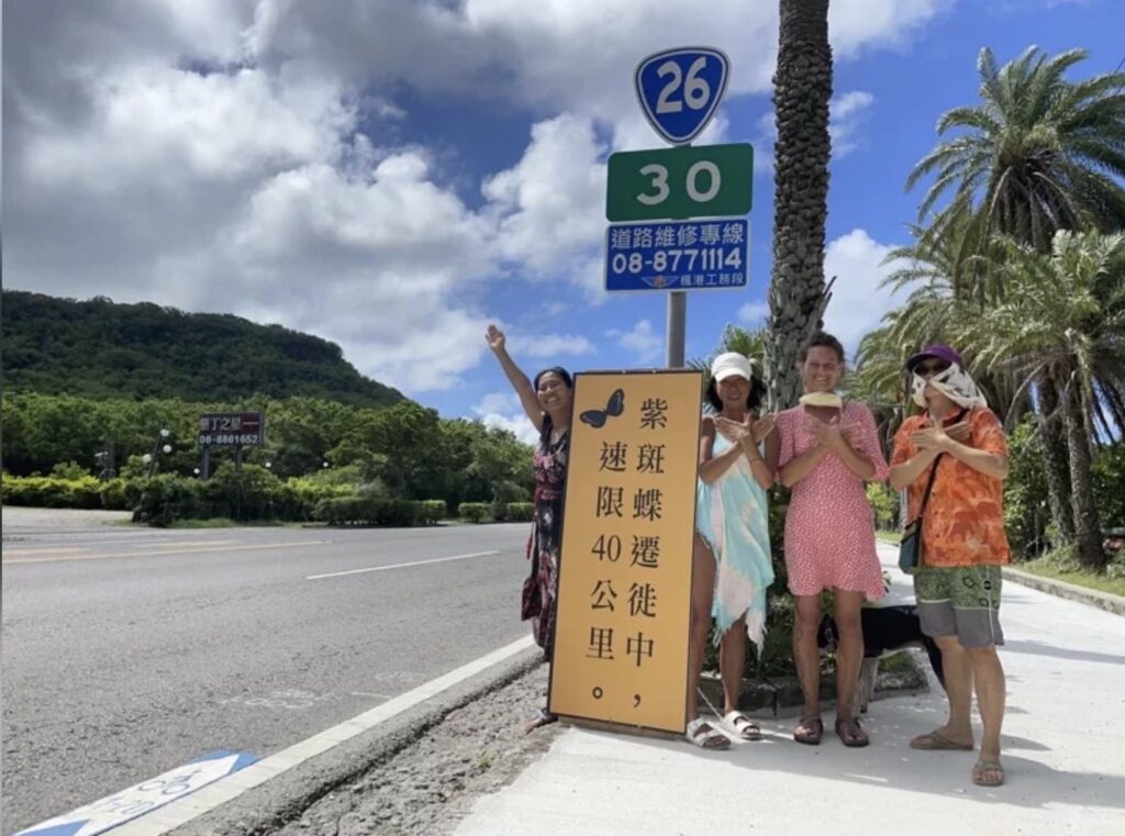 local team holds sign to butterfies